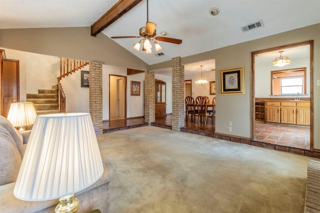 unfurnished living room featuring visible vents, a sink, carpet, decorative columns, and vaulted ceiling with beams