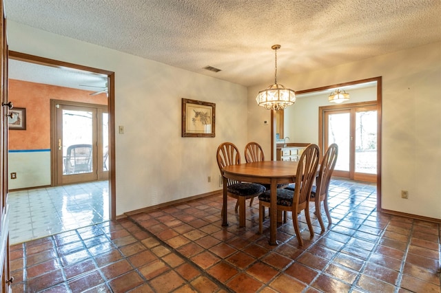 dining area with visible vents, baseboards, a textured ceiling, and a chandelier