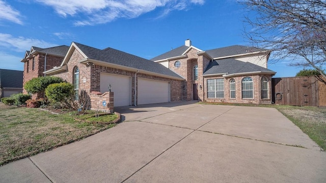 traditional-style home featuring an attached garage, brick siding, driveway, and a chimney