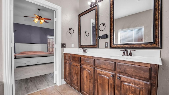 ensuite bathroom with double vanity, ensuite bathroom, a ceiling fan, and a sink