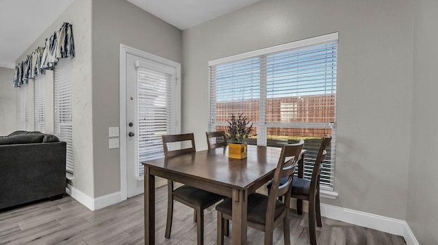 dining space featuring baseboards and light wood-style floors