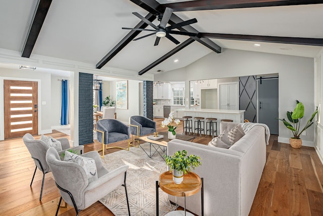 living room with baseboards, light wood-style flooring, vaulted ceiling with beams, and a ceiling fan