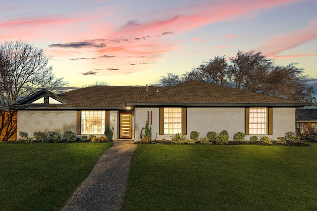 view of front of home featuring brick siding and a front lawn