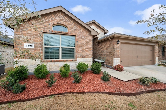 view of front of home with brick siding, driveway, and a garage