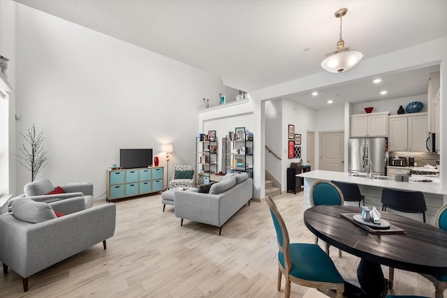 living room with stairway, recessed lighting, and light wood finished floors