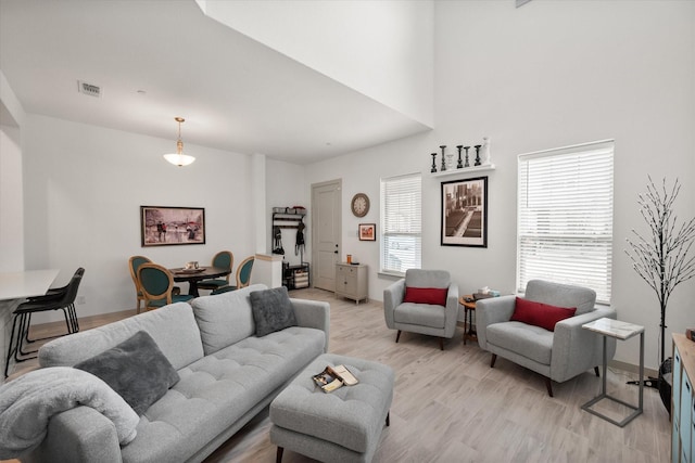 living room featuring visible vents, a healthy amount of sunlight, and light wood-style flooring