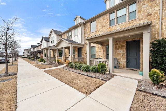 view of front facade featuring a residential view, stone siding, and a porch