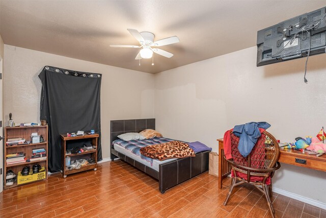 bedroom featuring a ceiling fan, baseboards, and wood tiled floor