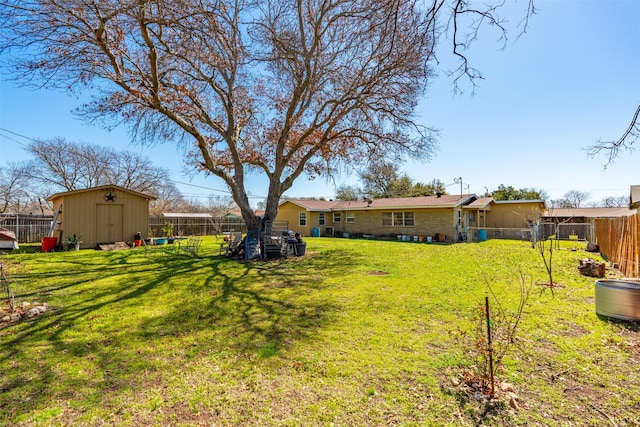 view of yard featuring a storage shed, a fenced backyard, and an outdoor structure