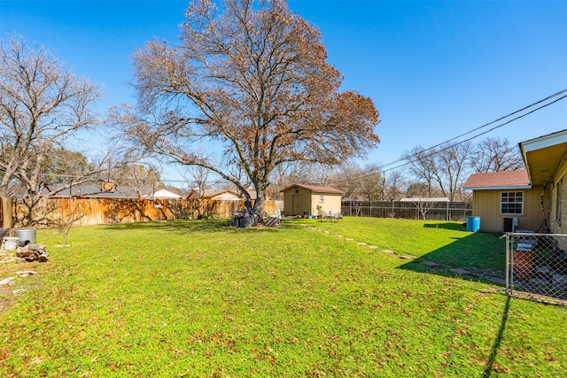 view of yard featuring an outbuilding, a fenced backyard, and a shed