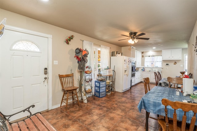 dining space featuring dark tile patterned floors and ceiling fan