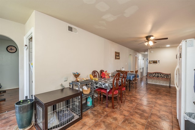 dining space featuring visible vents, arched walkways, baseboards, and ceiling fan