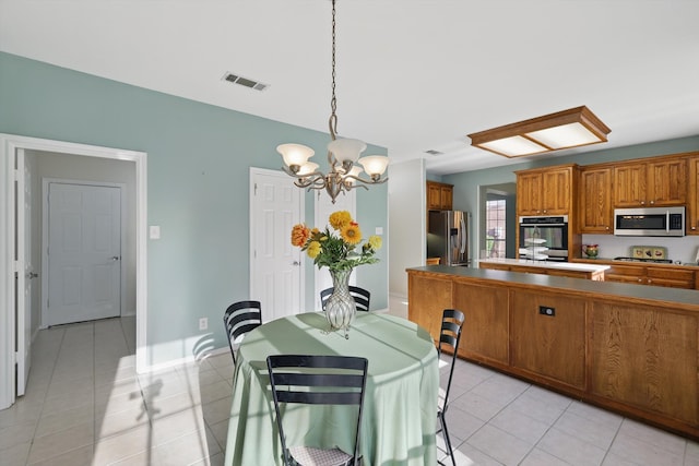 dining area with light tile patterned floors, baseboards, visible vents, and a chandelier