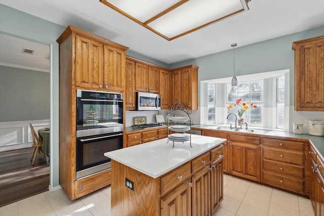 kitchen with backsplash, brown cabinets, appliances with stainless steel finishes, and a sink