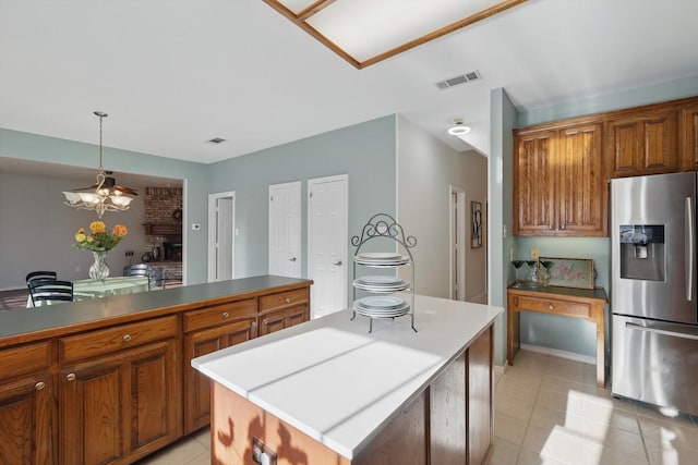 kitchen featuring visible vents, pendant lighting, brown cabinets, stainless steel refrigerator with ice dispenser, and light tile patterned flooring