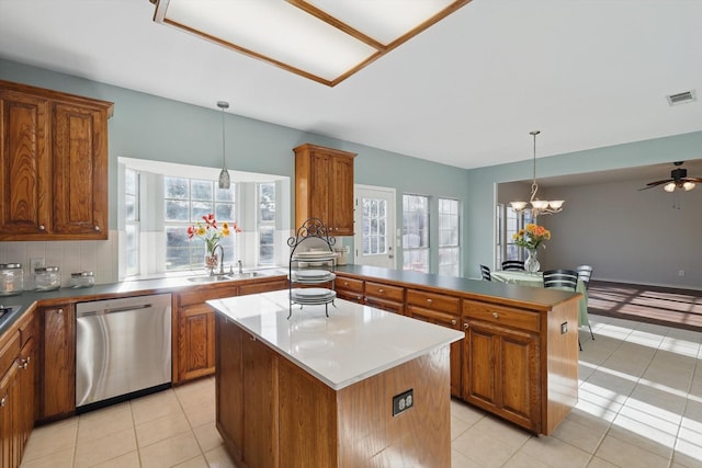 kitchen with dishwasher, a center island, brown cabinets, and a sink