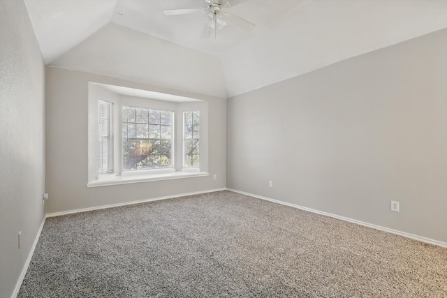 carpeted spare room featuring lofted ceiling, a ceiling fan, and baseboards