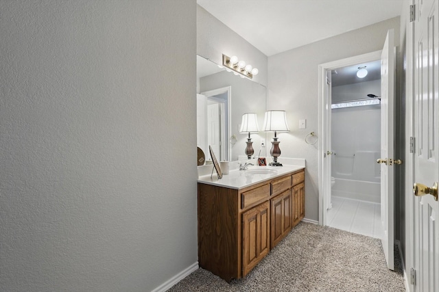 bathroom with vanity, toilet, a tub to relax in, and baseboards