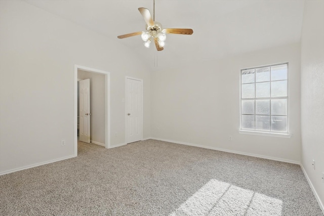 empty room featuring baseboards, lofted ceiling, carpet, and ceiling fan