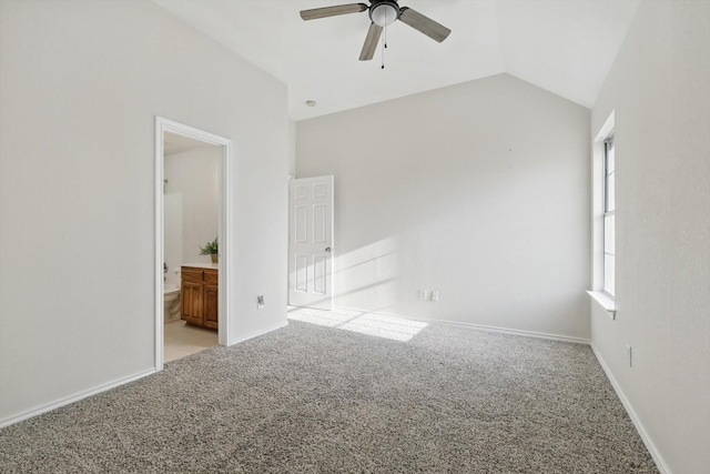 unfurnished bedroom featuring vaulted ceiling, carpet, baseboards, and ensuite bathroom