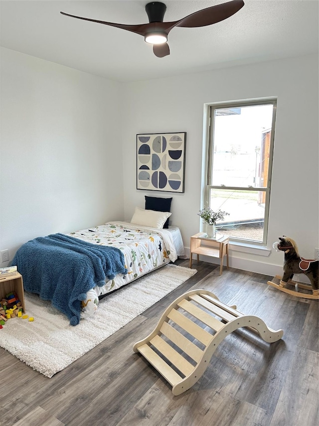 bedroom featuring a ceiling fan, wood finished floors, and baseboards