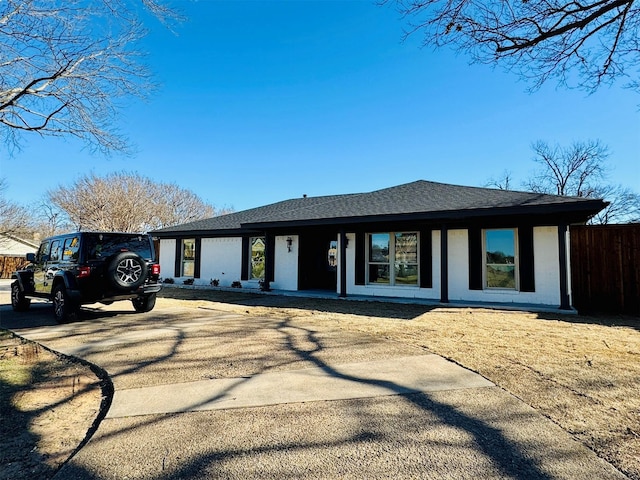 view of front of house with roof with shingles and fence