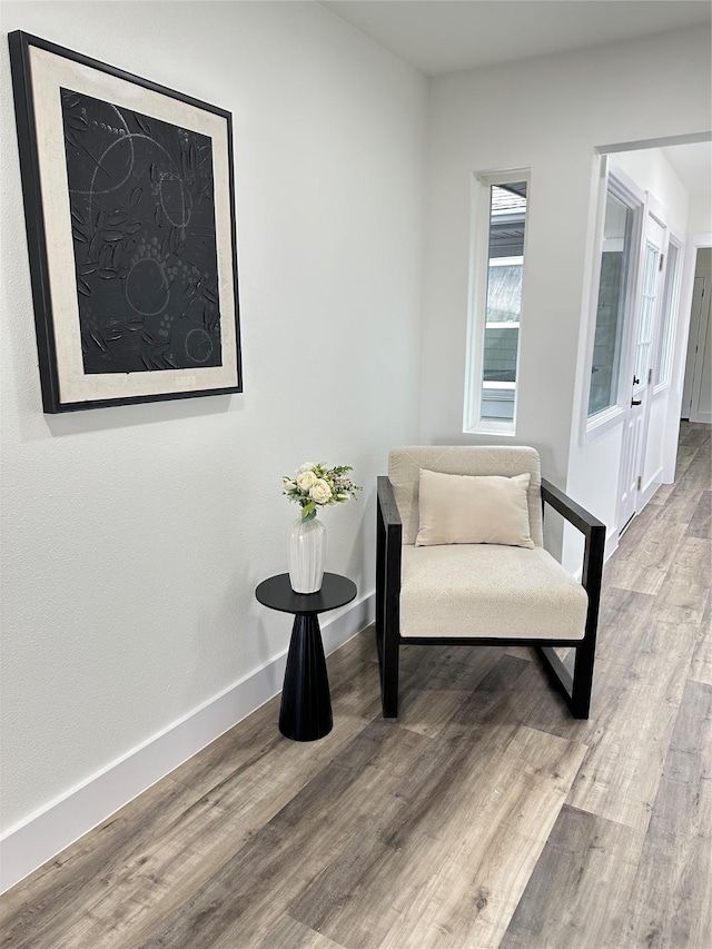 living area with baseboards and wood finished floors