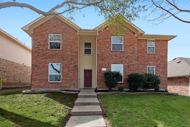 view of front facade featuring brick siding and a front yard