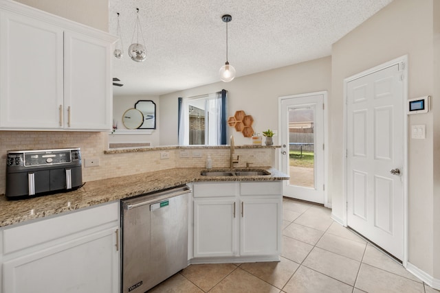 kitchen featuring dishwasher, a wealth of natural light, a peninsula, white cabinetry, and a sink