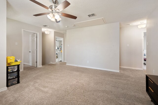 unfurnished room with baseboards, visible vents, carpet floors, attic access, and a textured ceiling