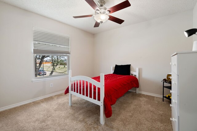 carpeted bedroom with a ceiling fan, baseboards, and a textured ceiling