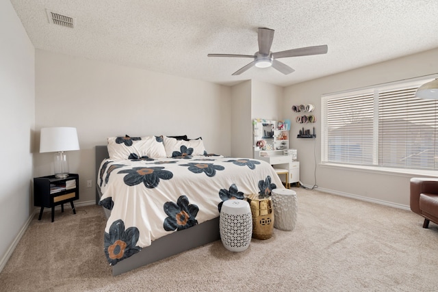 carpeted bedroom featuring baseboards, visible vents, and a textured ceiling