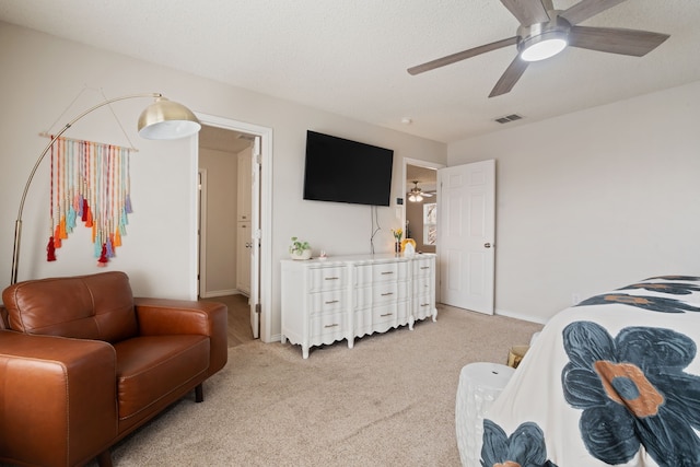 bedroom featuring baseboards, visible vents, ceiling fan, a textured ceiling, and light carpet