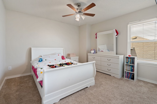 bedroom with light colored carpet, baseboards, ceiling fan, and multiple windows