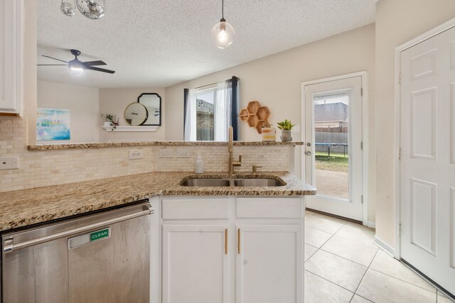 kitchen with dishwasher, light tile patterned floors, white cabinetry, and a sink