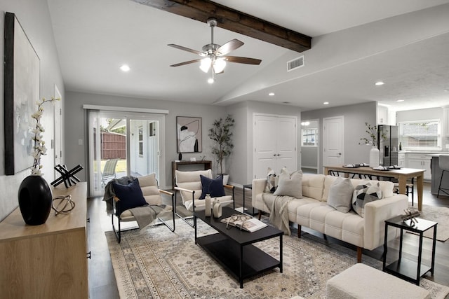 living room with a wealth of natural light, light wood-type flooring, recessed lighting, and vaulted ceiling with beams