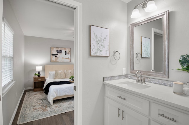 bathroom featuring vanity, wood finished floors, and baseboards