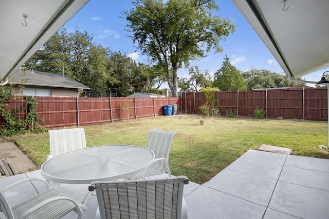 view of yard with a fenced backyard, outdoor dining area, and a patio