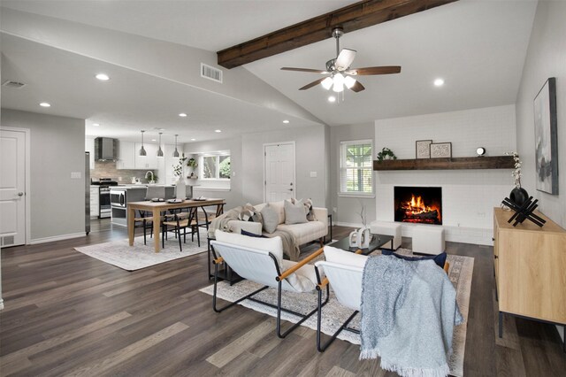 living area with lofted ceiling with beams, a healthy amount of sunlight, visible vents, and dark wood-style flooring