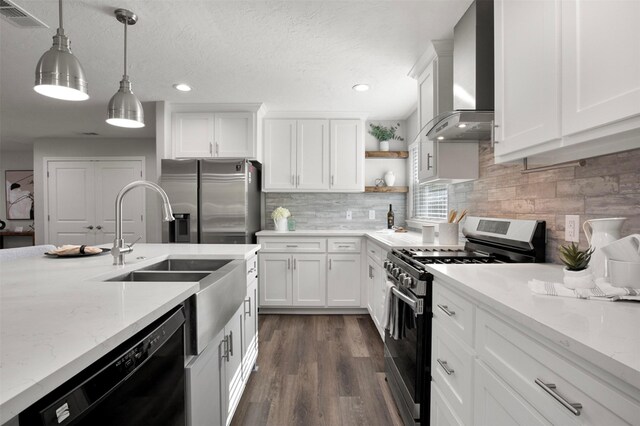 kitchen featuring visible vents, hanging light fixtures, stainless steel appliances, wall chimney exhaust hood, and open shelves