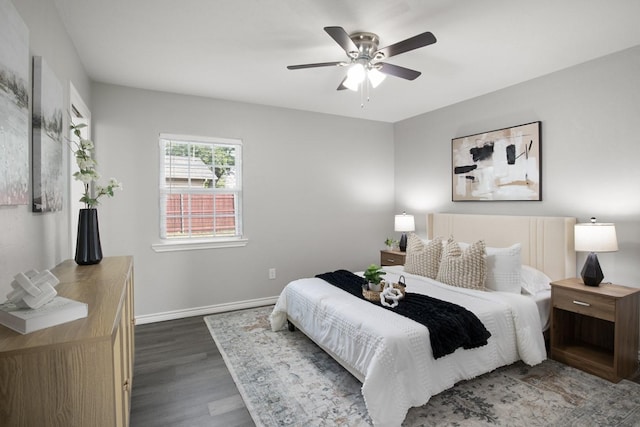 bedroom with a ceiling fan, baseboards, and wood finished floors