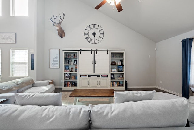 living area featuring a ceiling fan, baseboards, and high vaulted ceiling