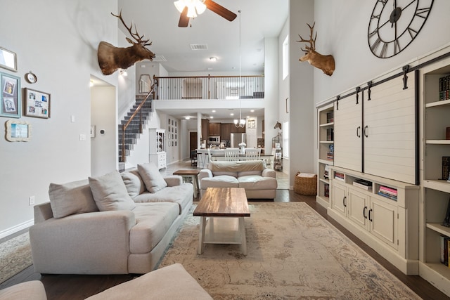 living room with ceiling fan, stairway, visible vents, and dark wood finished floors