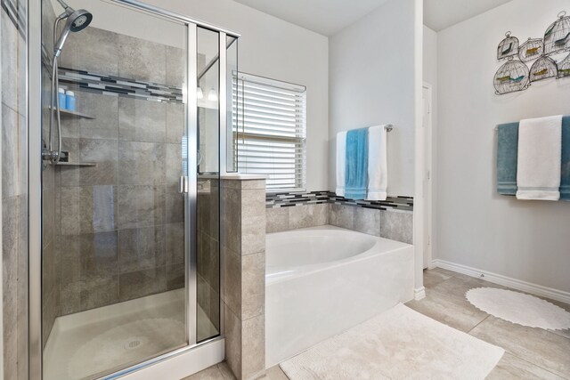 full bath with tile patterned floors, a shower stall, baseboards, and a garden tub