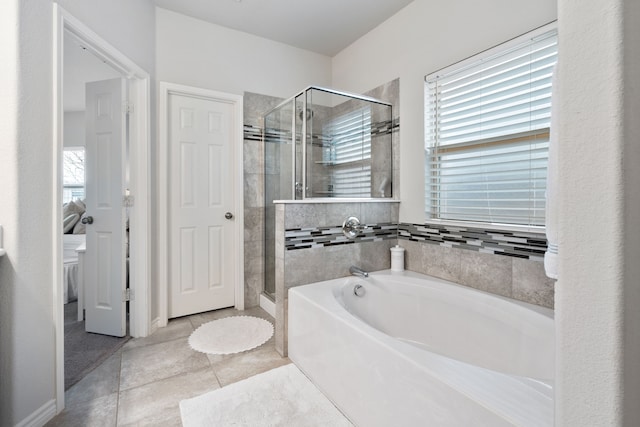 bathroom with tile patterned flooring, a shower stall, and a garden tub