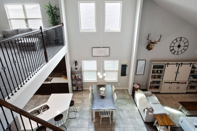 living room featuring tile patterned floors, plenty of natural light, stairway, and a high ceiling