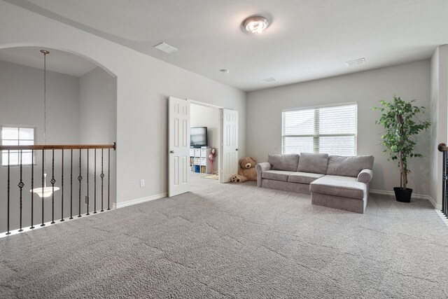 carpeted living area featuring visible vents and baseboards