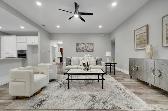 living area featuring light wood-type flooring, baseboards, visible vents, recessed lighting, and ceiling fan
