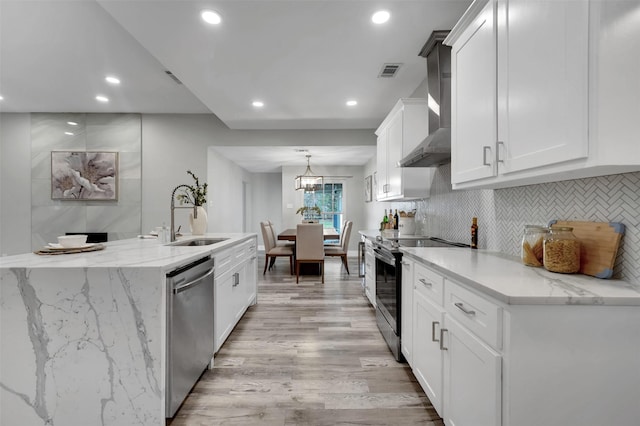 kitchen featuring a sink, wall chimney exhaust hood, appliances with stainless steel finishes, visible vents, and recessed lighting