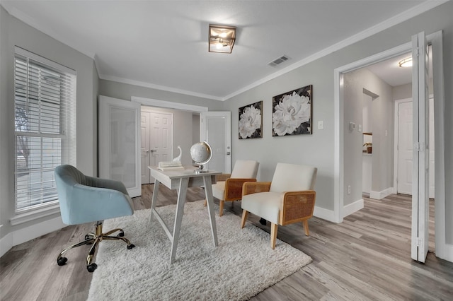 office with baseboards, light wood-style floors, visible vents, and plenty of natural light